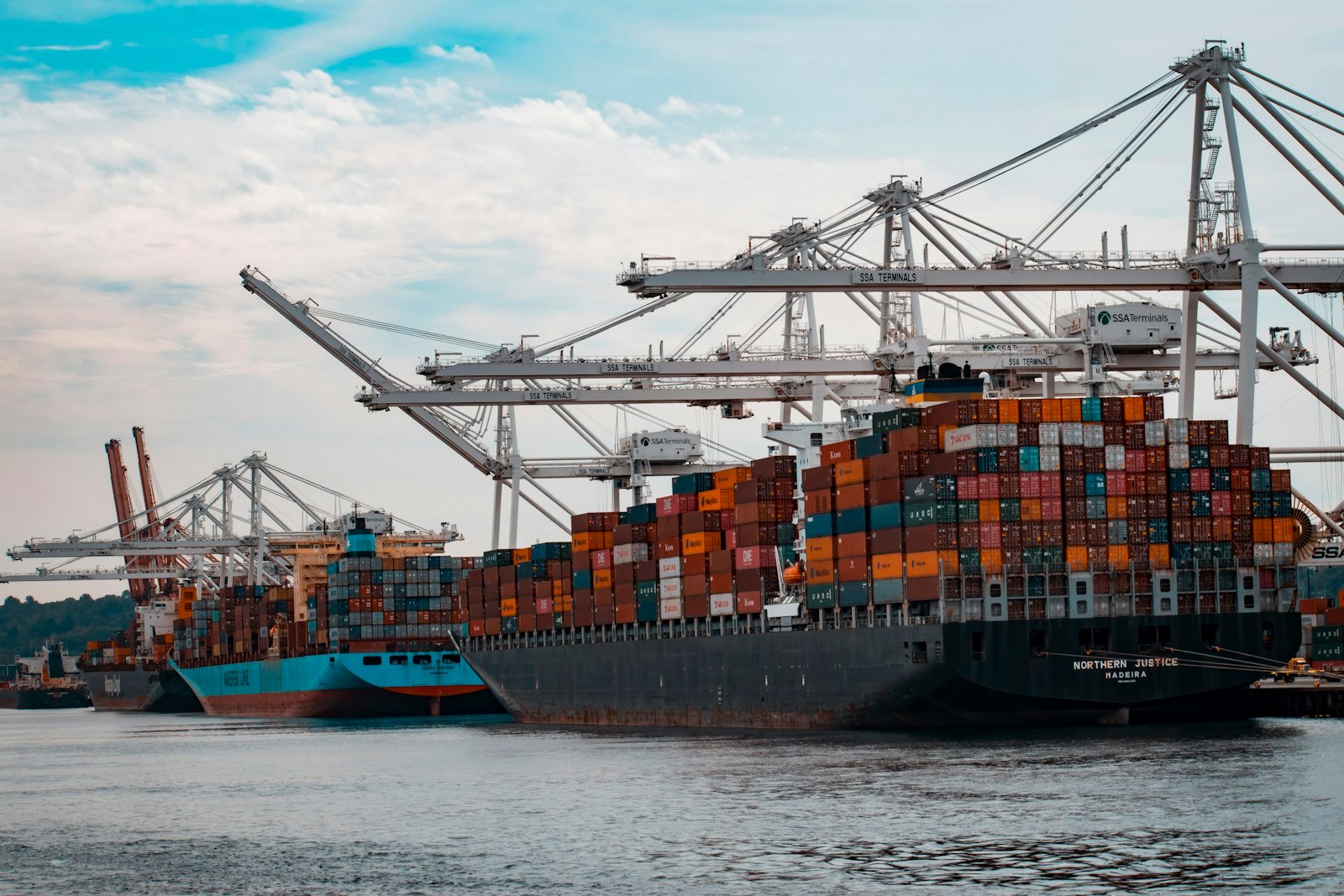 Cranes working over a container ship at a commercial port